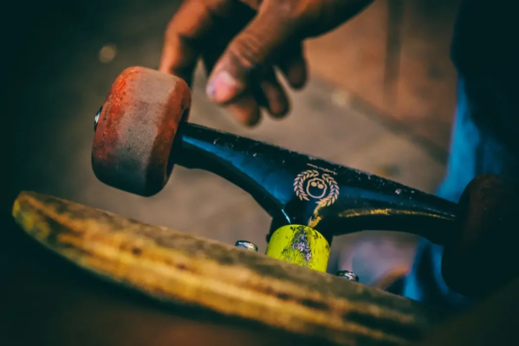 Close-up of a hand on skateboard trucks and wheels