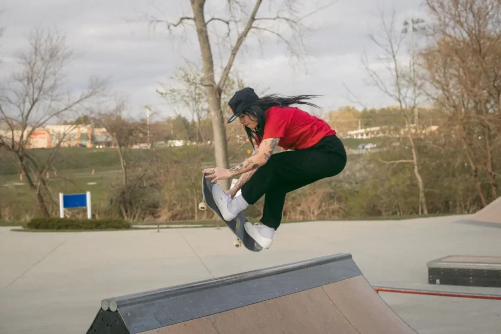 A skateboarder doing an aerial trick at a skatepark