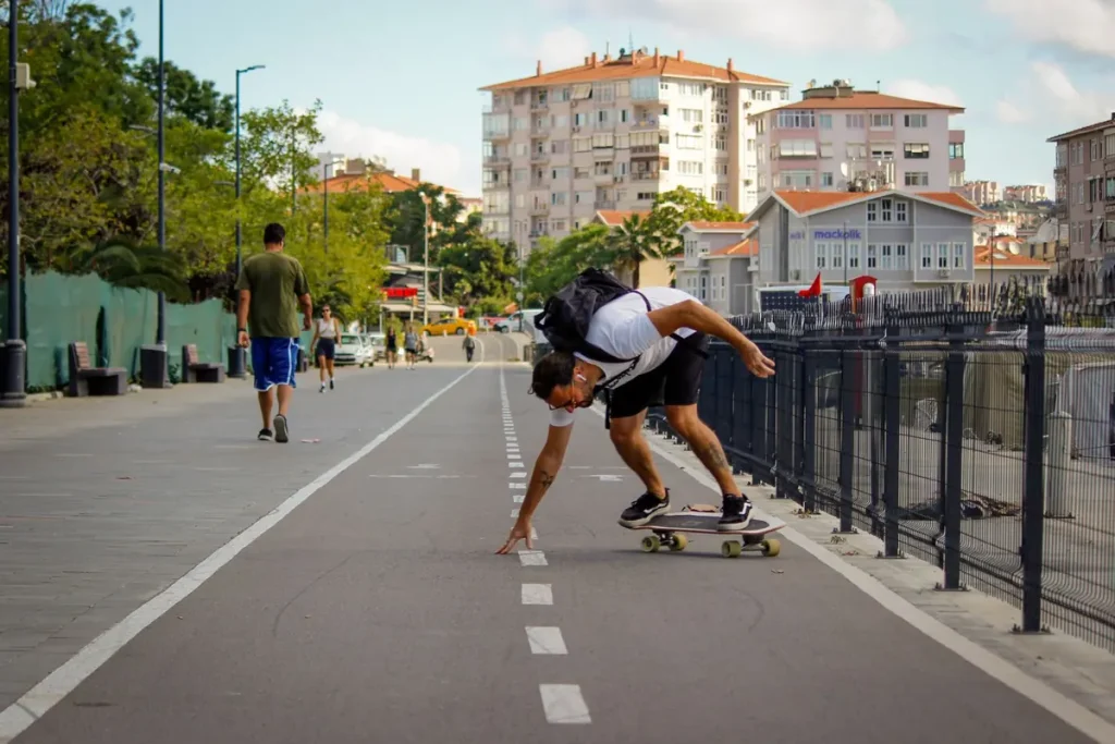 A man skateboarding along a city promenade