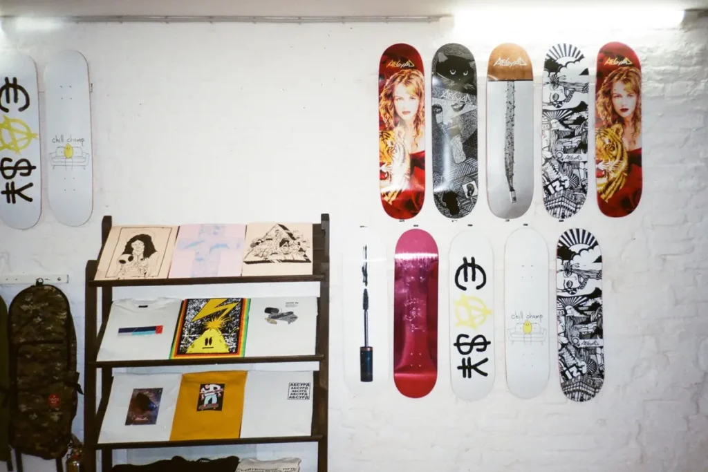 Skateboards and prints displayed on a white brick wall