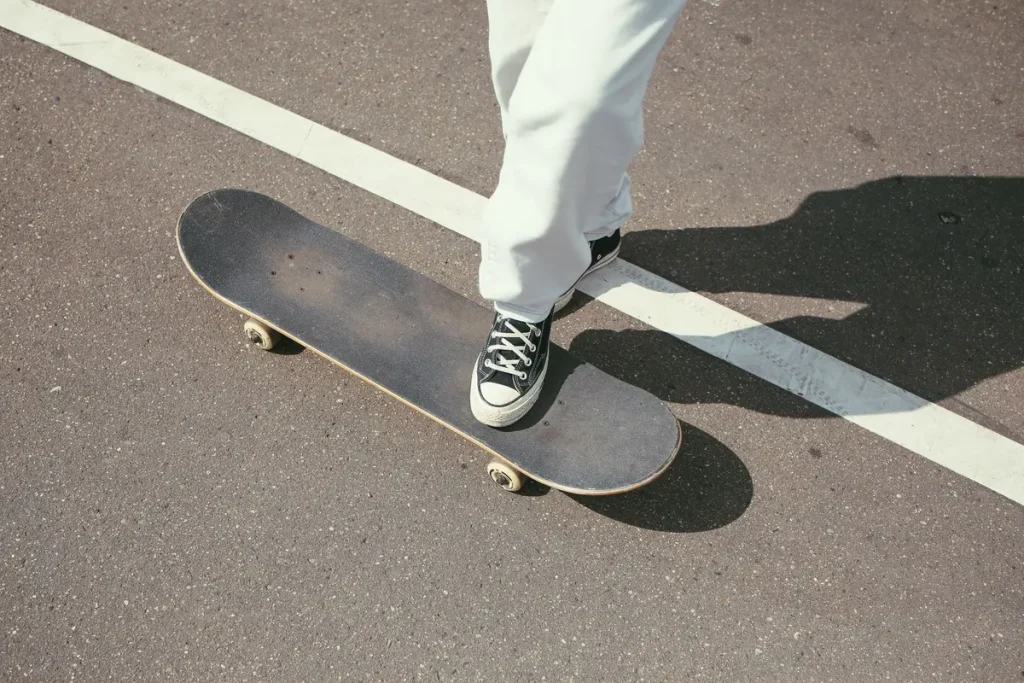 A skateboarder's foot balancing on a board on a sunny street