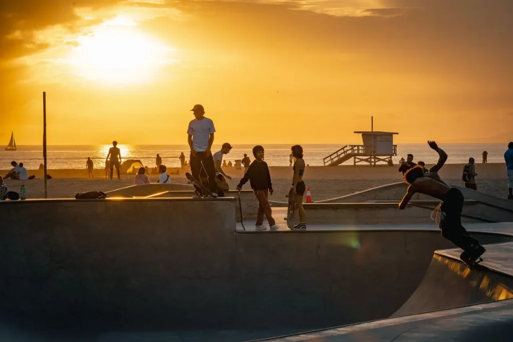 Skaters at a skatepark at sunset