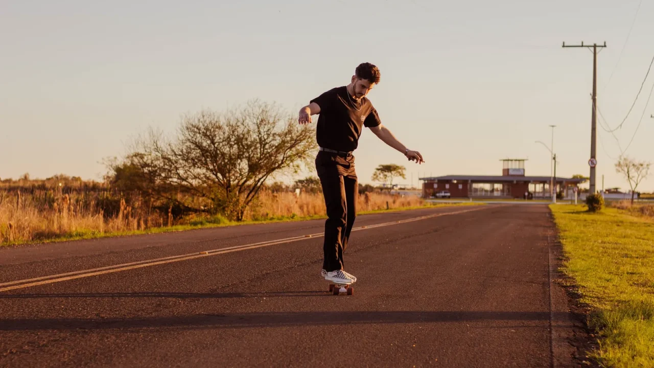 A young man skateboarding on a rural road